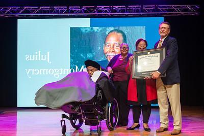 Julius Montgomery receiving his doctorate plaque